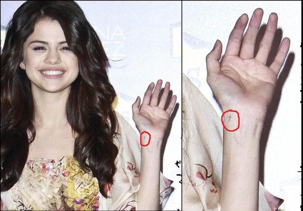 selena gomez has a little cross on her wrist but it's not a tattoo just