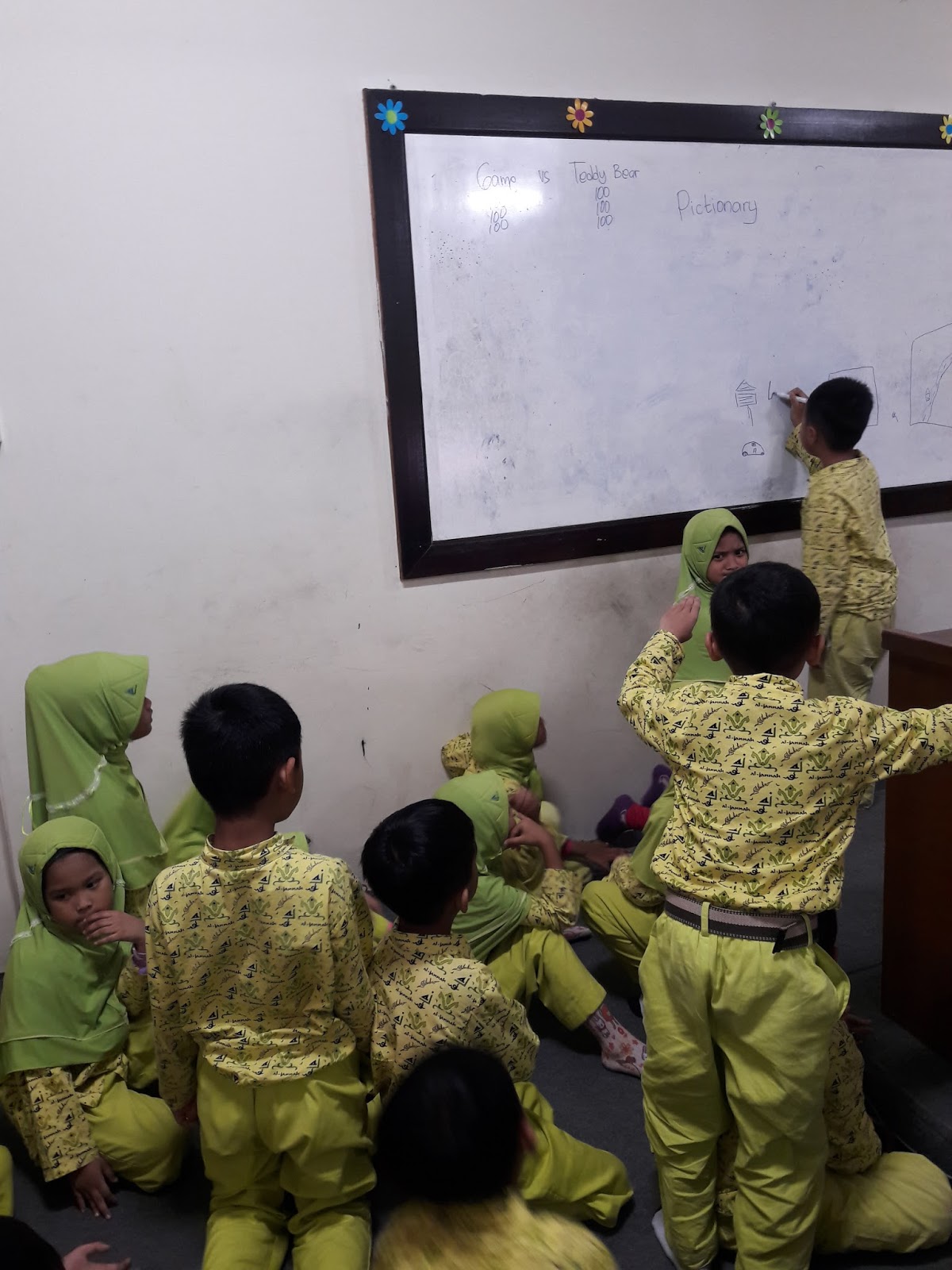 satu anak maju dan yang lain mencoba mengira ngira gambar apakah itu