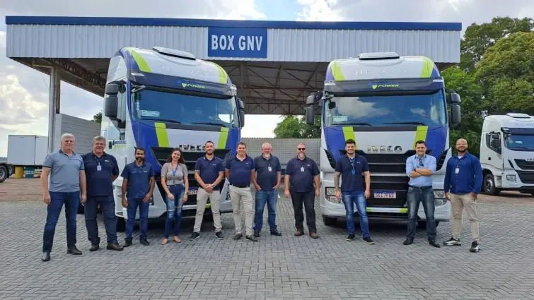 Caminhão Iveco Branco a Gás com pessoas em sua frente