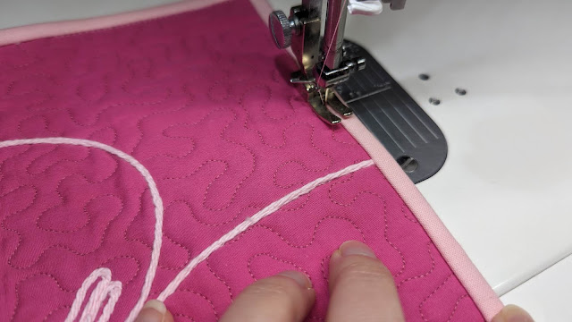 Machine sewing binding onto a quilt