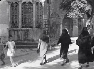 صورة ل نساء من عكا – بلبس الملايه اللباس الشعبي لاهل عكا عام 1934م وهو لباس يشبه لباس نساء الشام