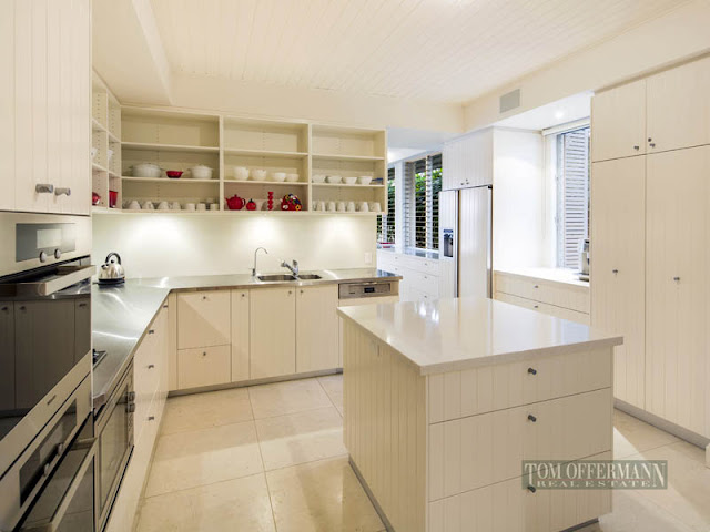 Photo of modern white kitchen with small kitchen island in the middle