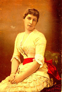 seated young woman posing with yellow dress and red sash