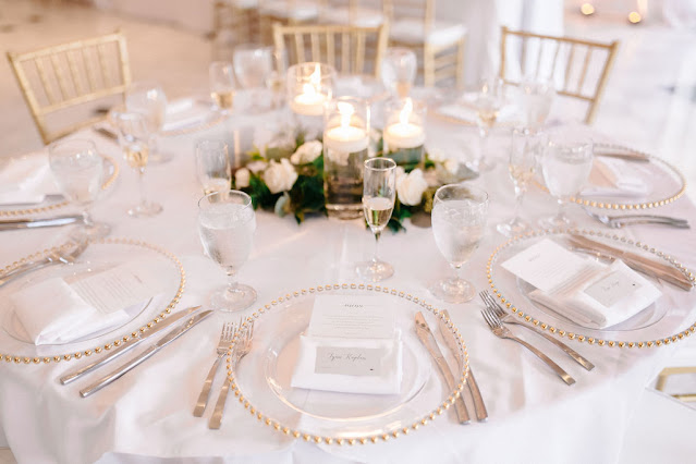 wedding reception tables with white linen and floral centerpieces