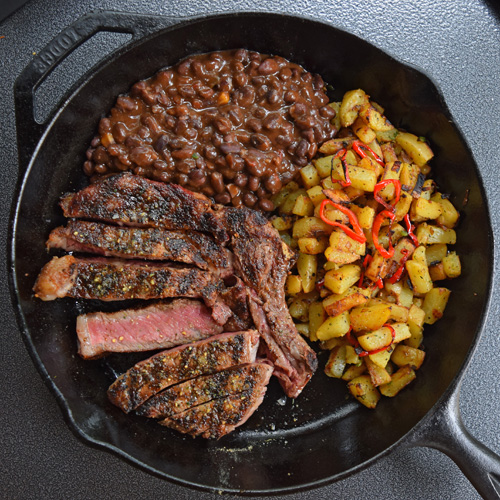 Cowboy Ribeye Steak, crispy potatoes, and bush's best Sidekicks