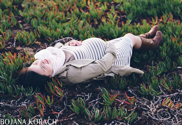 pregnant woman laying on the ground touching her pregnant belly captured by san francisco photographer