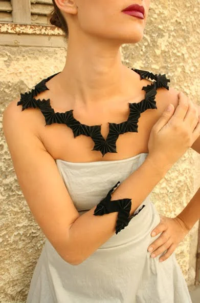 folded black paper necklace and bracelet on model