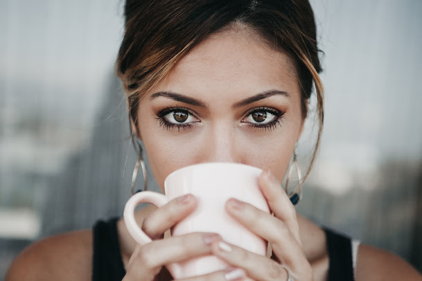 Beautiful girl drinking tea in a white cup