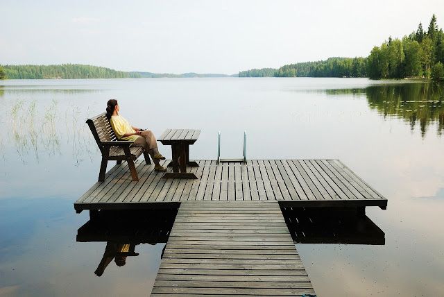 Photo of Woman sitting by peaceful lake