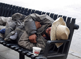 A homeless man laying down on a cold public bench. Jesus was homeless. Do you think He would cross the street to avoid the homeless? Or do you think Jesus would have compassion and feed the homeless with bread and fish?