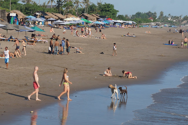 A mix of tourists and local enjoying the black sand beach of Canggu in Bali