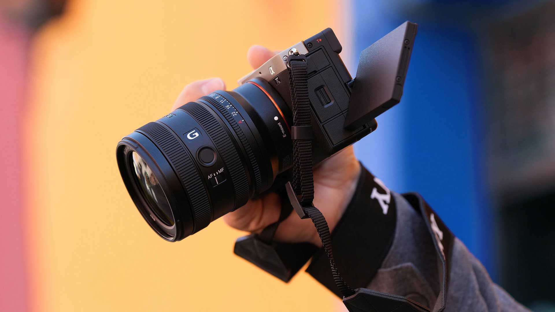 Рука фотографа держит камеру с объективом Sony FE 24-50mm f/2.8 G