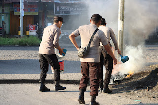 Demo Bubar, Pihak Kepolisian Bersihkan Sisa Pembakaran Ban.