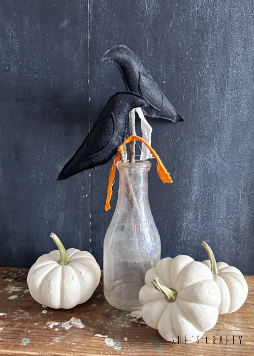 Primitive crows on sticks in a jar for fall home decor.