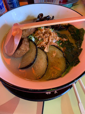 Cuenco de ramen. Lleva unas rodadajas de berenjena, alga, algo que parece pollo pero es proteína vegetal y cebolla crujiente.