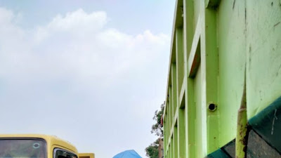  Jalan Raya Maja Jasinga, yang seharusnya menjadi jalur utama, kini dipenuhi oleh parkir mobil dum truck pengangkut tanah merah, memicu perhatian publik