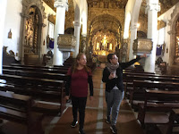 guia brasileira mostrando detalhes de igreja para turista brasileira