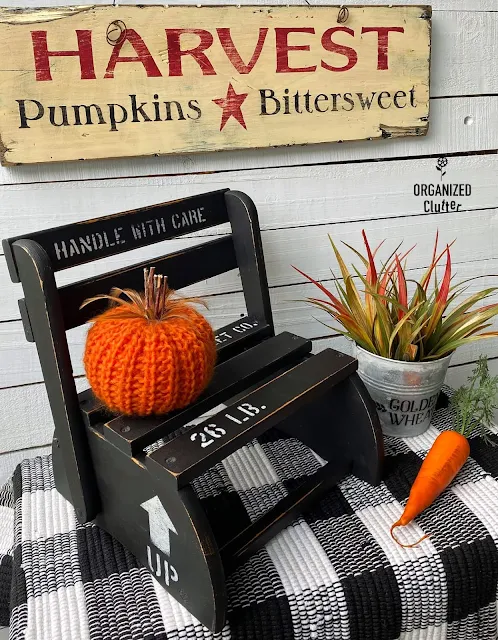 Photo of an upcycled folding step stool/chair staged with fall decor