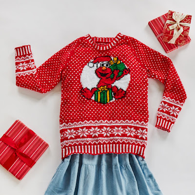 Flatlay of a red festive jumper with allover colourwork and large Elmo motif