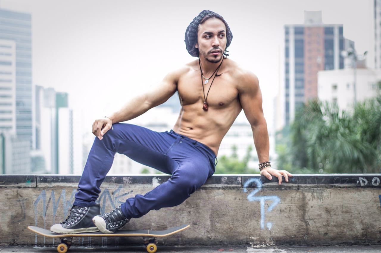 Modelo Ricardo Dias exibe shape trincado ao andar de skate pela cidade