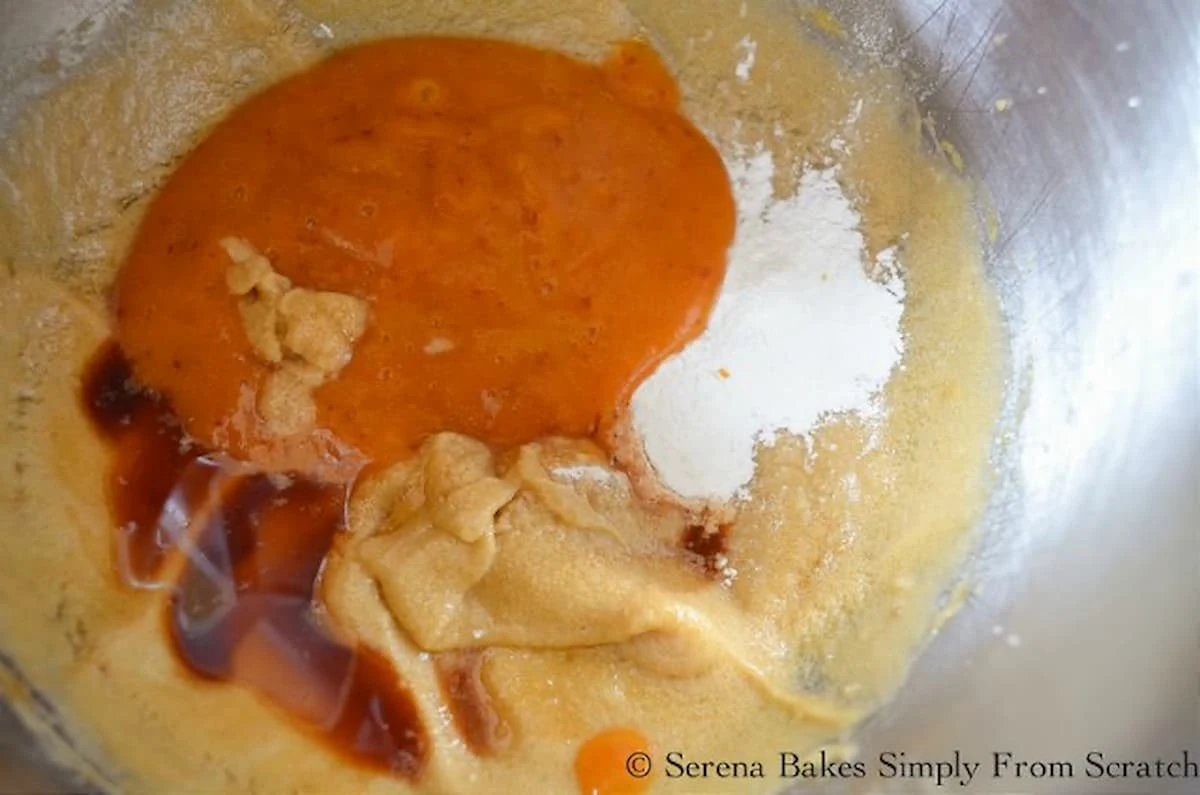 Baking Powder, Salt, Vanilla, and Peach Puree added to Peach Upside Down Cake batter in a stainless steel mixing bowl.