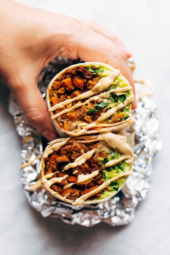 These Vegan Mega-Burritos are stuffed with a sweet potato, cauliflower, and walnut taco meat filling, plus the usual suspects of avocado, salsa, and a heavy thwap of vegan cashew queso! Versatile, quick to make, and seriously SO GOOD.