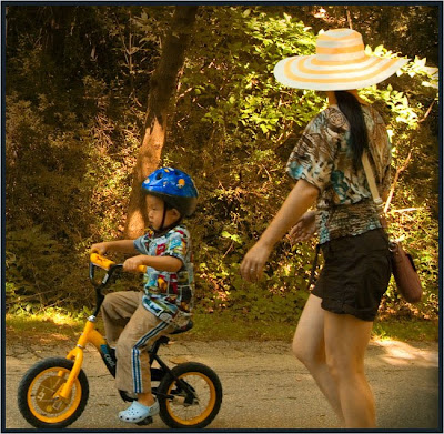 Boy on trike and mom with sun hat, Toront portrait photographer Robert Rafton