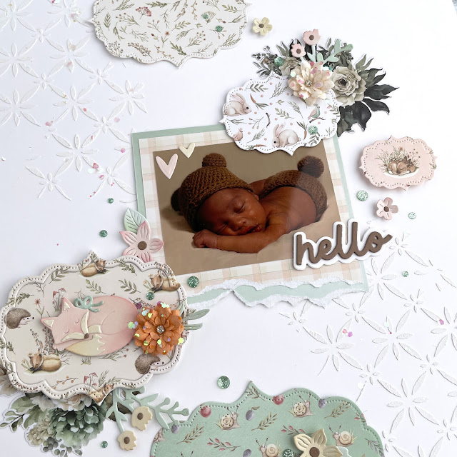Mixed media scrapbook layout decorated with Scrapbook.com Magic Meadow collection, Unicorn Shimmer Flakes, Cloud Whip, Nested Stitched Labels; and Prima Marketing The Home Baker collection ephemera and paper flowers.