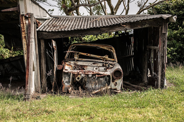 old wrecked car in collapsing garage