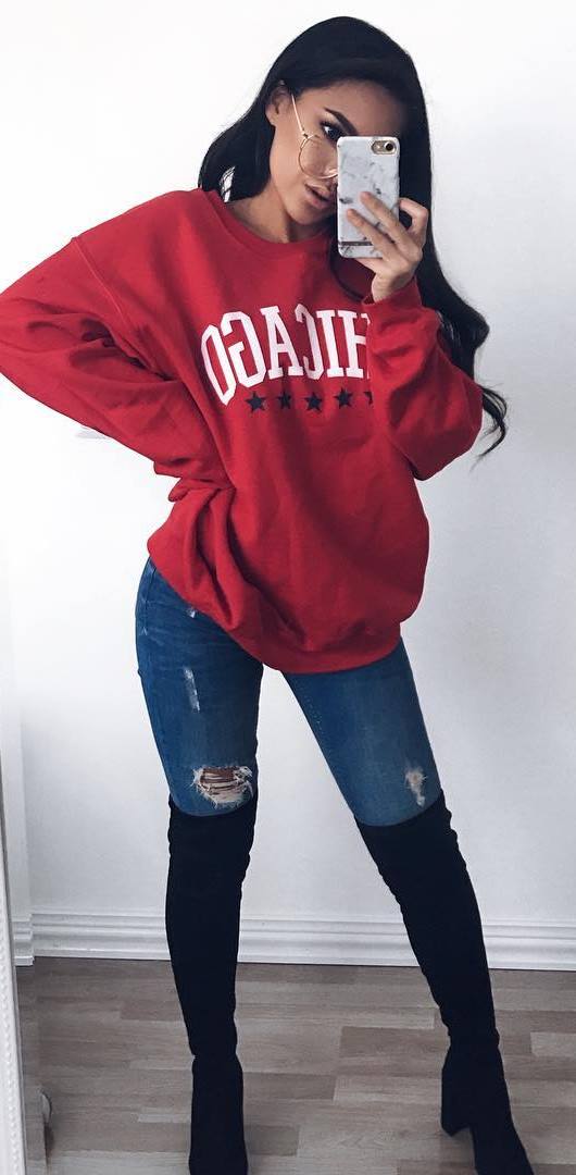 winter outfit idea / red printed sweatshirt + rips + black over knee boots