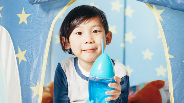 child in play tent with rocket shaped water bottle