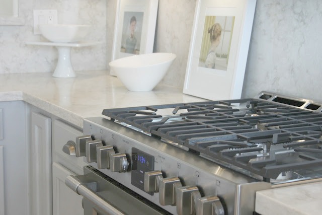 Serene chic simple Nordic French kitchen with grey cabinets and Soprano quartz countertop and backsplash