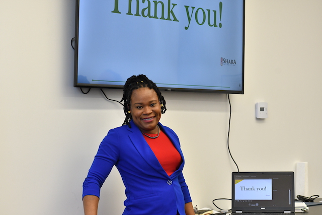 Woman in front of TV screen presenting in a classroom