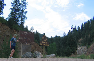 Terry touching the sign at the top of the canyon road