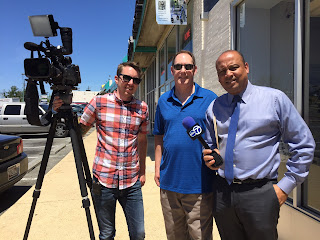 WJLA reporter Horace Holmes (right), with his cameraman (left) and Mark Wright, working on storefront crash story.