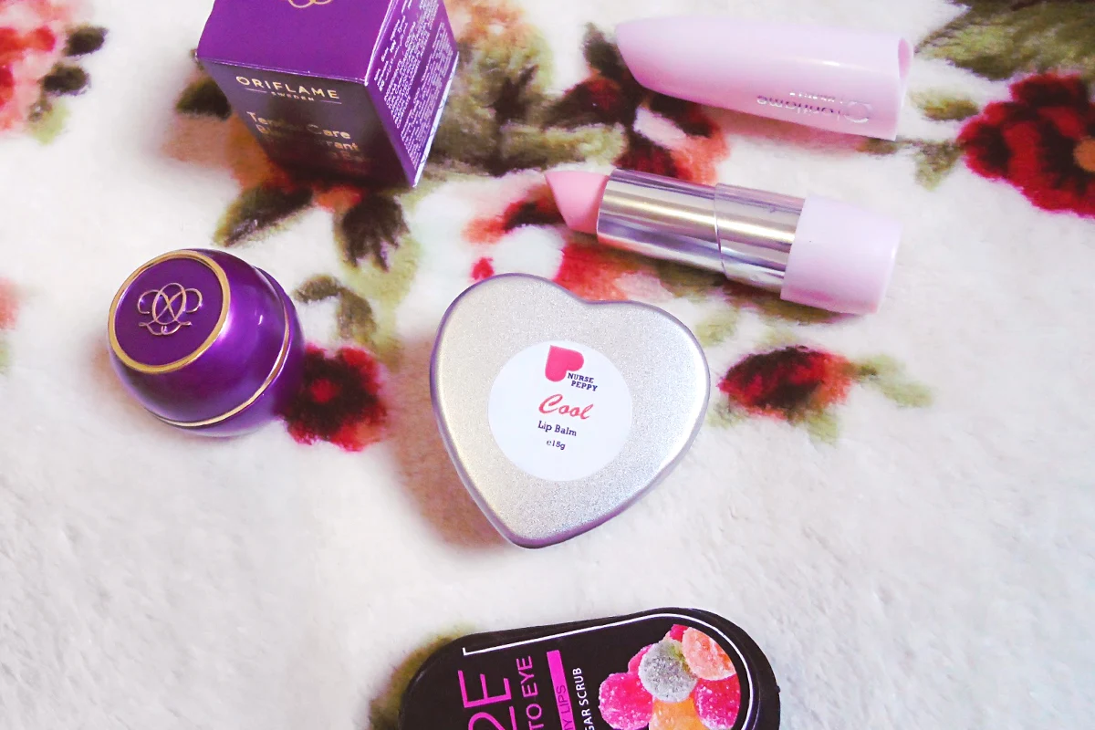 flatlay with four lip care products laying on top of a blenket