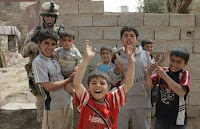 Iraqi children pose with Marine 1st Sgt. Robert W. Breeden during a patrol through Ramadi, Iraq. The patrols, performed with Iraqi Police, maintain security and assess the condition of the area.