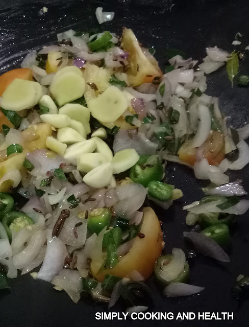 Adding tomato with garlic and ginger