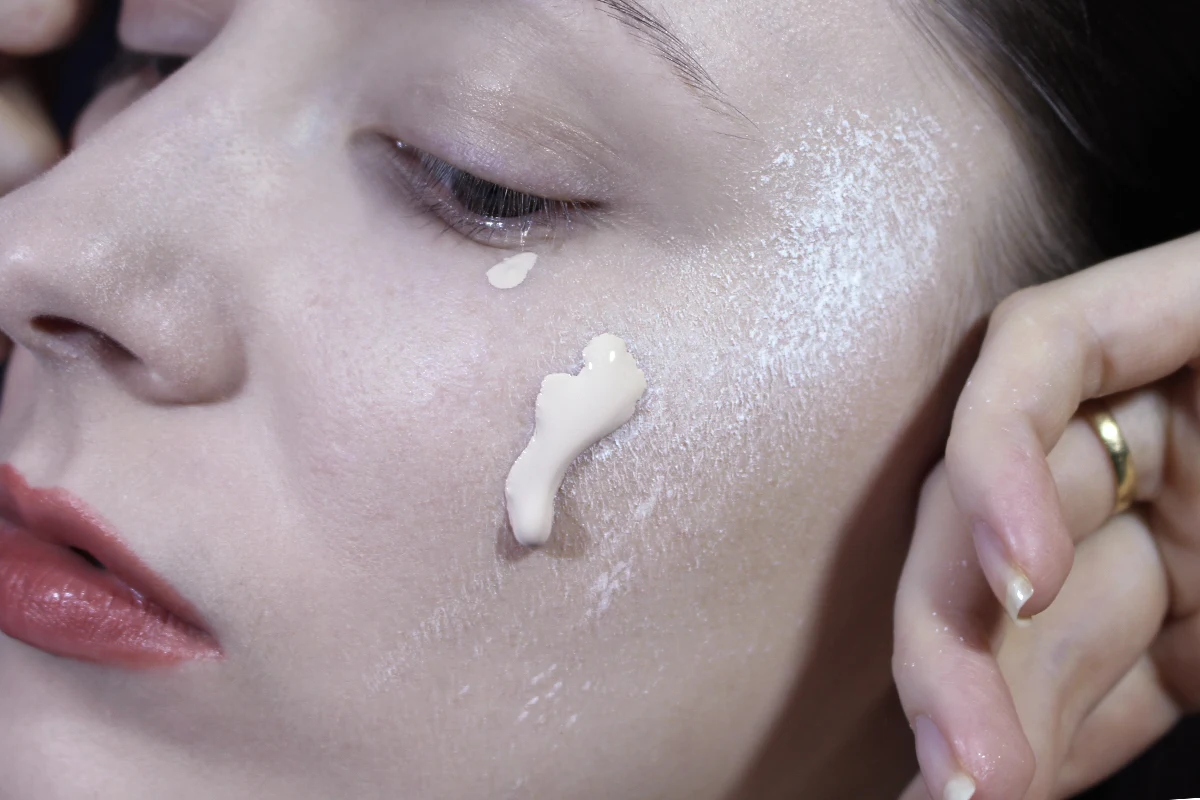 close-up of woman's face with makeup foundation and powder sloppily applied onto the skin