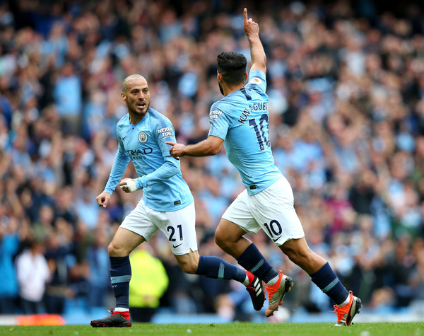 Sergio Aguero of Manchester City celebrates with teammate David Silva after scoring his team's first goal during the Premier League match between Manchester City and Huddersfield Town at Etihad Stadium on August 19, 2018 in Manchester, United Kingdom.