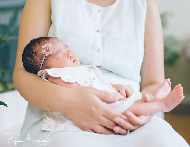 newborn baby girl sleeping in mother's arms