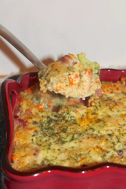 Serving spoon scooping cheddar ham and broccoli quinoa casserole.