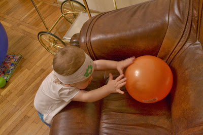 a small girl is playing the ball, the arm chair