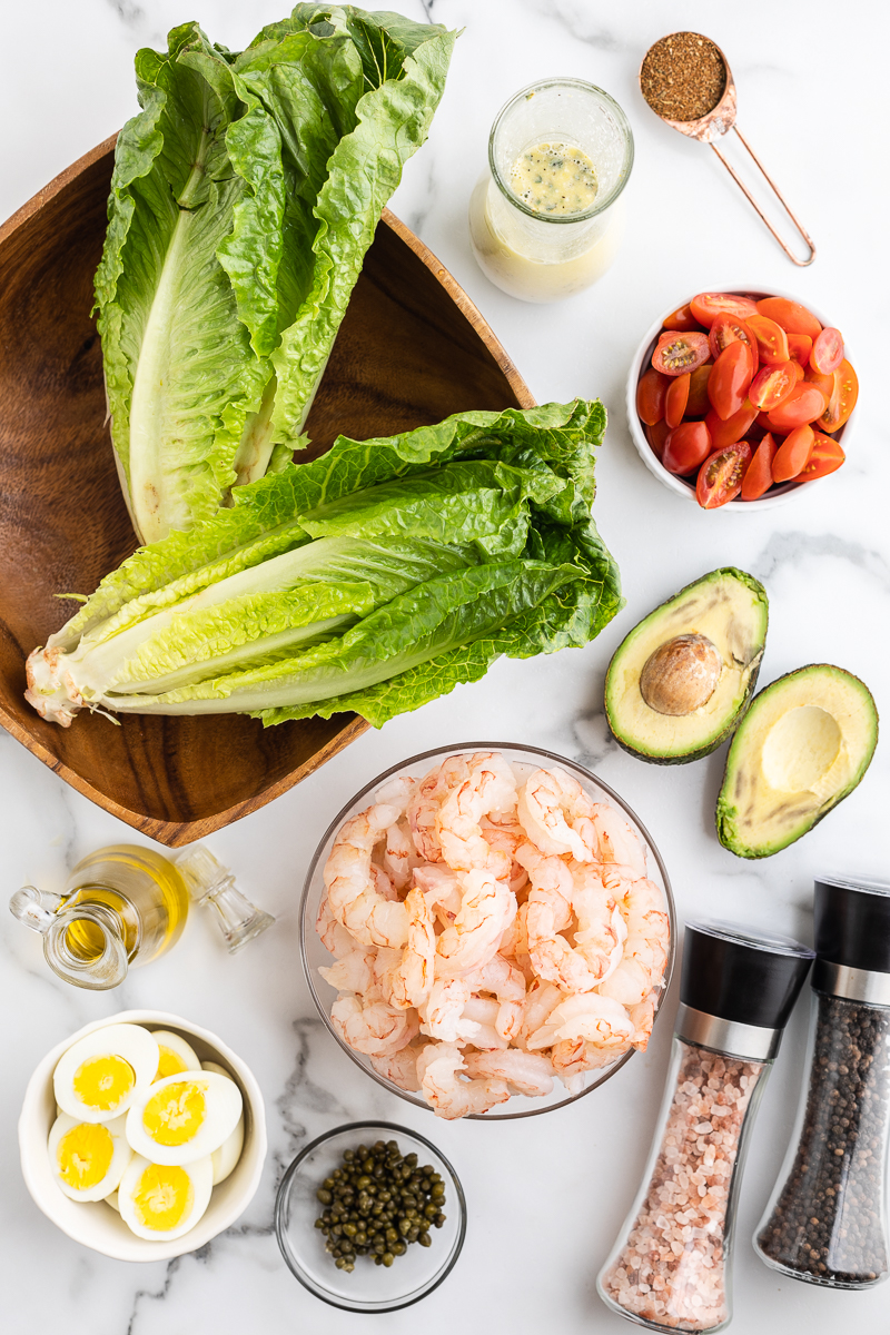 Overhead photo of the ingredients needed to make Low-Carb Shrimp Louise Salad on a white marble counter.