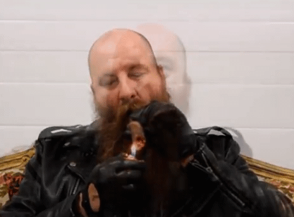 1/3 bald leather Master wearing full leather gear receives fellatio smoking a cigar