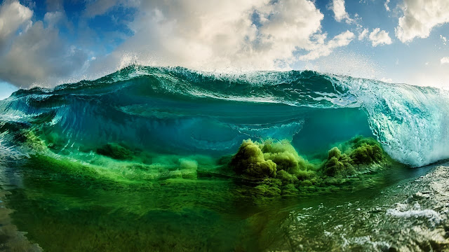 Arrebentação se formando com um contraste único de cores. A areia tem tons esverdeados e o mar é azul translúcido.