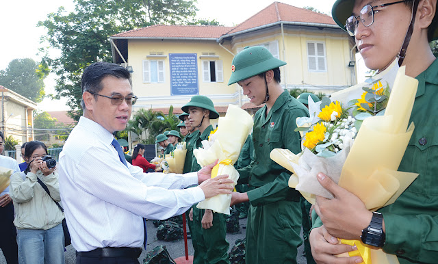 Đồng chí Nguyễn Văn Dũng tặng hoa chúc mừng các tân binh. (Ảnh: AH)