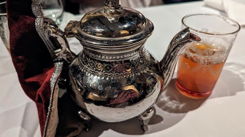 Moroccan tea pot and mint tea poured in small glass