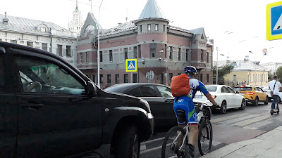 Яузкий бульвар в Москве, водитель нарушает правила, двигаясь по велосипедной дорожке за велосипедистом. Особняк Филипповых. Август 2022 года