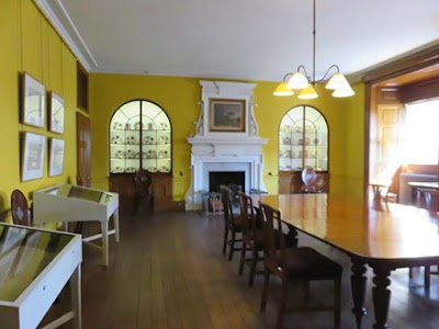 large room with built in shelves and bright yellow walls